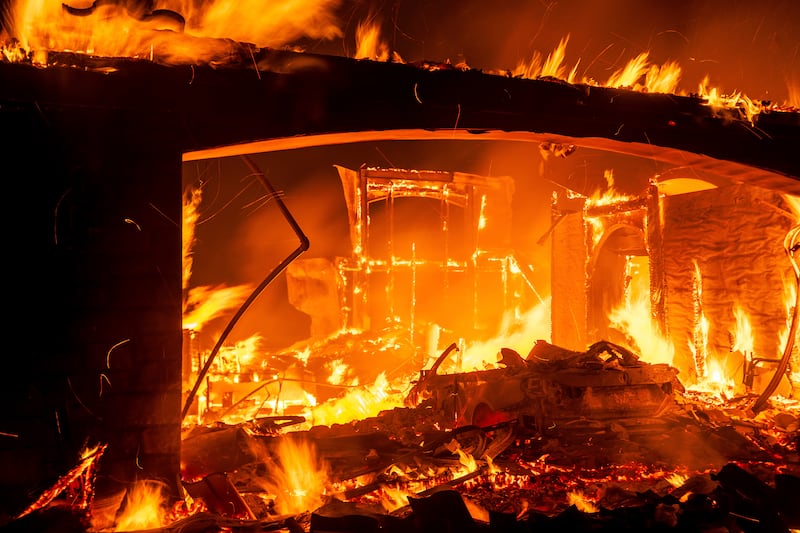 Flames consume a home as the mountain fire burns in Camarillo, California (Noah Berger/AP)