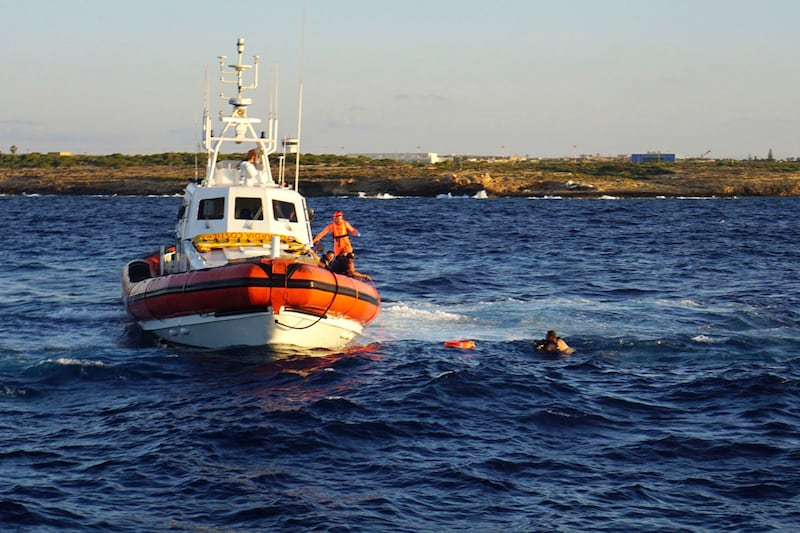 A man who threw himself in the water from the Open Arms vessel is intercepted by Italian coast guards (Francisco Gentico/AP)