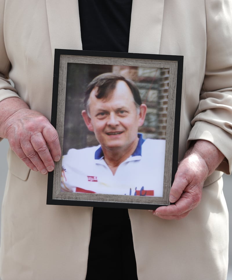 Bridie Brown, the widow of murdered GAA official Sean Brown, holds a picture of him, outside the Royal Courts of Justice in Belfast