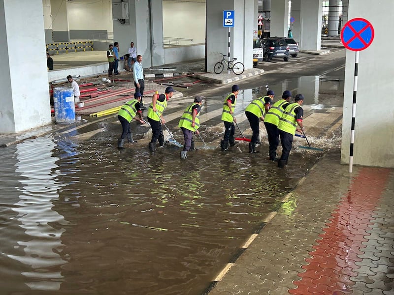 Crews worked to remove water outside the airport following a heavy downpour (Shonal Ganguly/AP)