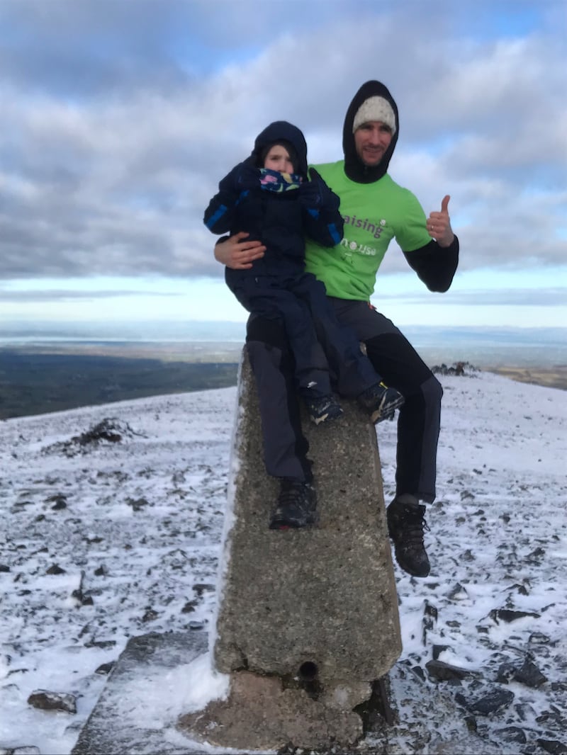 Man and boy sitting on a stump 