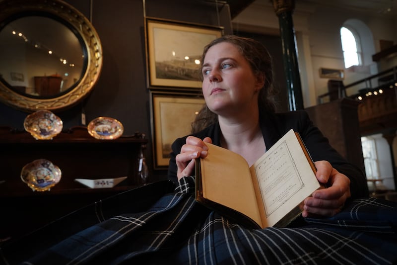 Cath Marsden of Lyon and Turnbull holds the copy of Robert Burns’ book of poems, which is expected to fetch around £60,000.