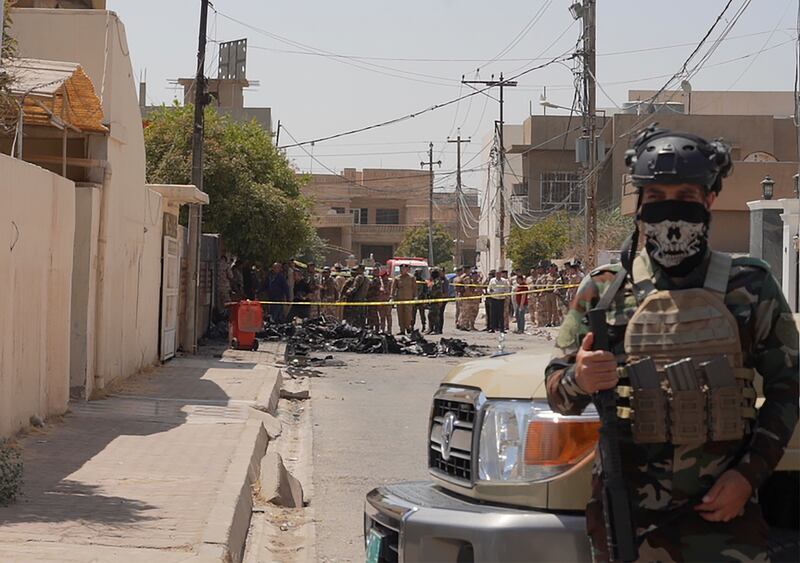 Iraqi Army soldiers stand guard near the debris of a drone shot down by Iraq’s air defences in Kirkuk, Iraq (AP)