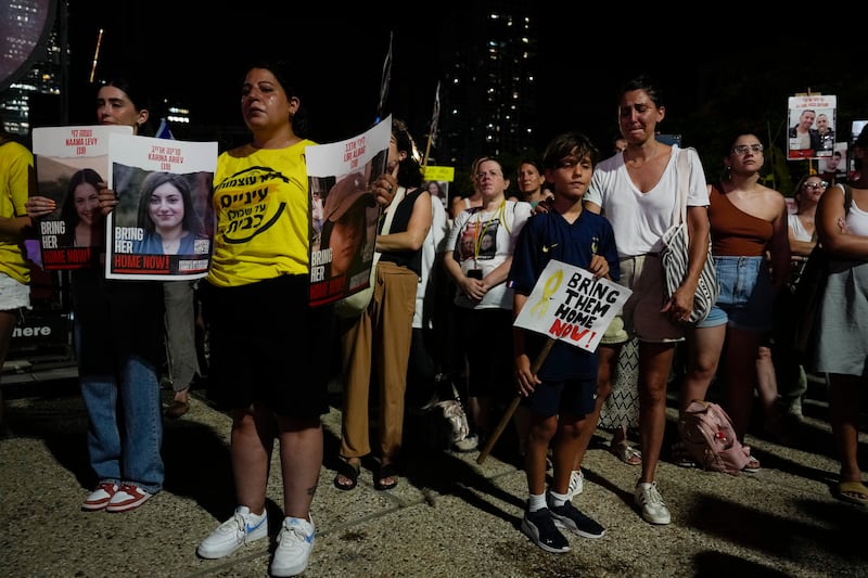 People hold signs with photos of Israeli hostages, demanding their release as they watch Prime Minister Benjamin Netanyahu’s speech before the US Congress (AP Photo/Ariel Schalit)