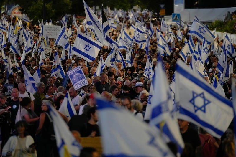People wave Israeli flags during a protest against Israeli Prime Minister Benjamin Netanyahu’s government, demanding new elections and the release of the hostages held in the Gaza Strip by the Hamas militant group (Ohad Zwigenberg/AP)