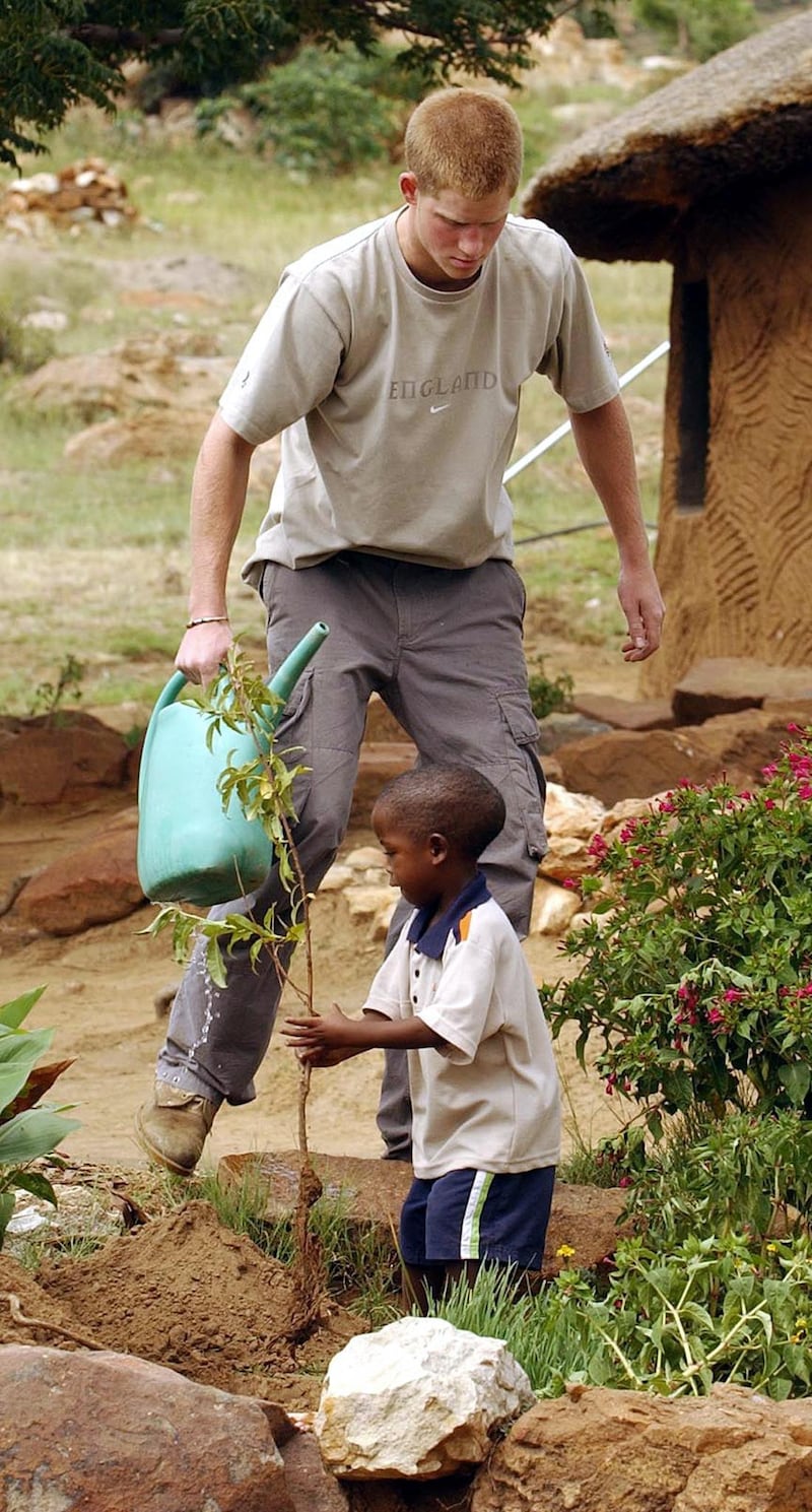 Harry and four-year-old Mutsu Potsane planting a peach tree together at the Mants’ase Children’s Home in Lesotho in 2004