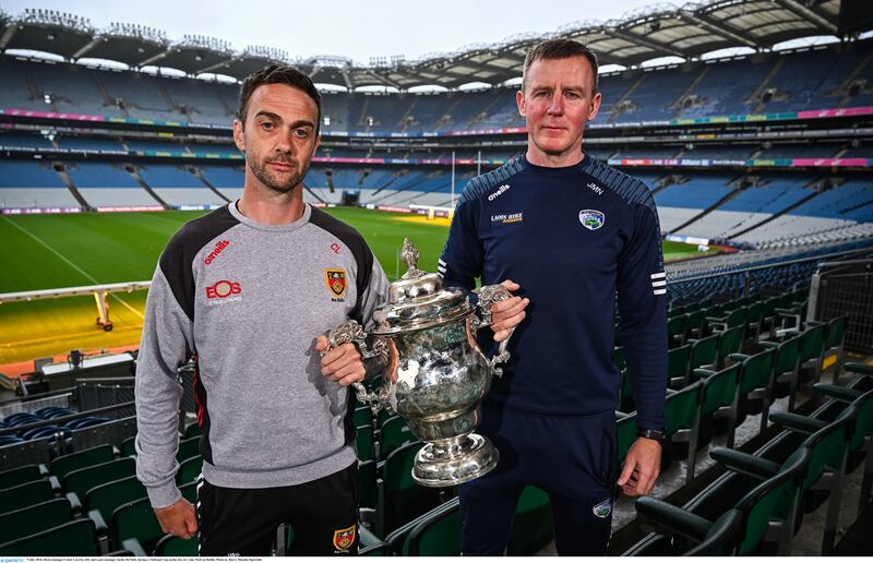 Down manager Conor Laverty and Laois manager Justin McNulty hold the Tailteann Cup between them at Croke Park