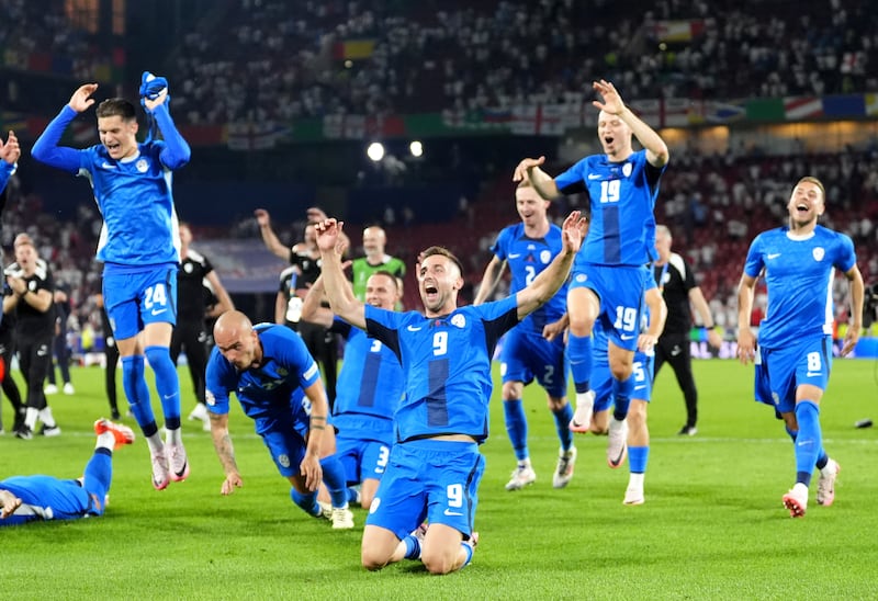 Slovenia players celebrate reaching the round of 16 following their draw against England