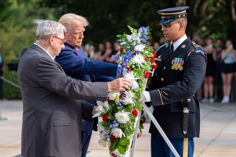 Bill Barnett, left, grandfather of Darin Taylor Hoover, and former president Donald Trump place a wreath at the Tomb of the Unknown Solider (Alex Brandon/AP)