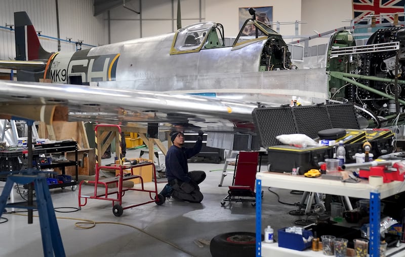 An engineer works on the restoration of a Spitfire inside the Heritage Hangar at Biggin Hill Airport in Kent. .