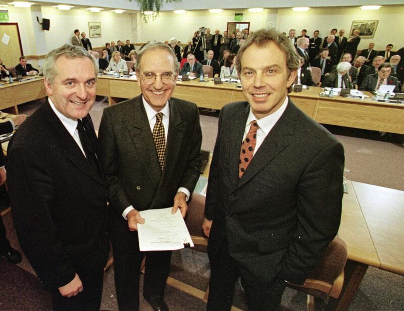 Former Prime Minister Tony Blair (right), former US Senator George Mitchell (centre) and former Taoiseach Bertie Ahern smiling after signing the Good Friday Agreement in April 1998