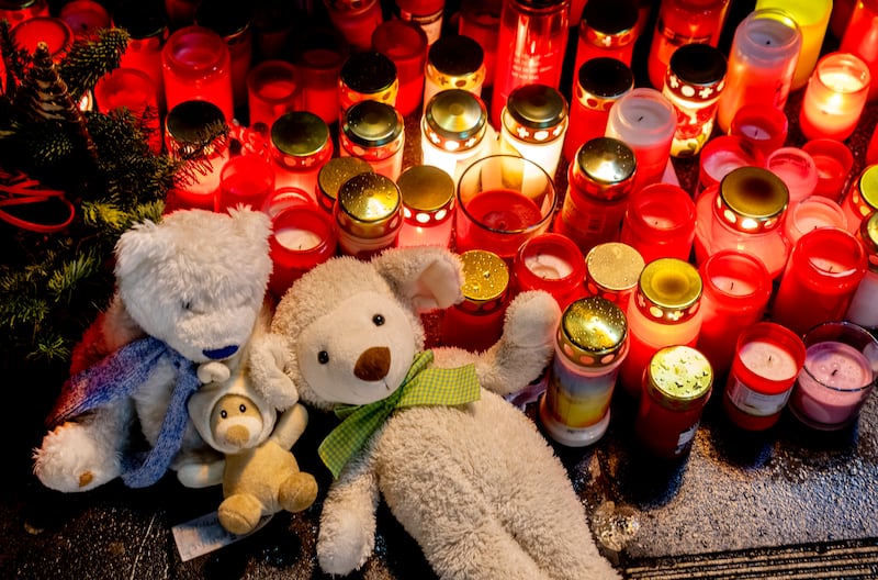 Teddy bears and candles have been left near the scene of the incident (Michael Probst/AP)