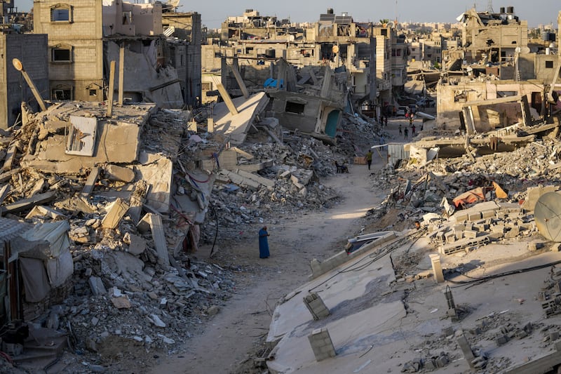 Palestinians walk through the destruction left by the Israeli air and ground offensive on Khan Younis, Gaza Strip (AP)