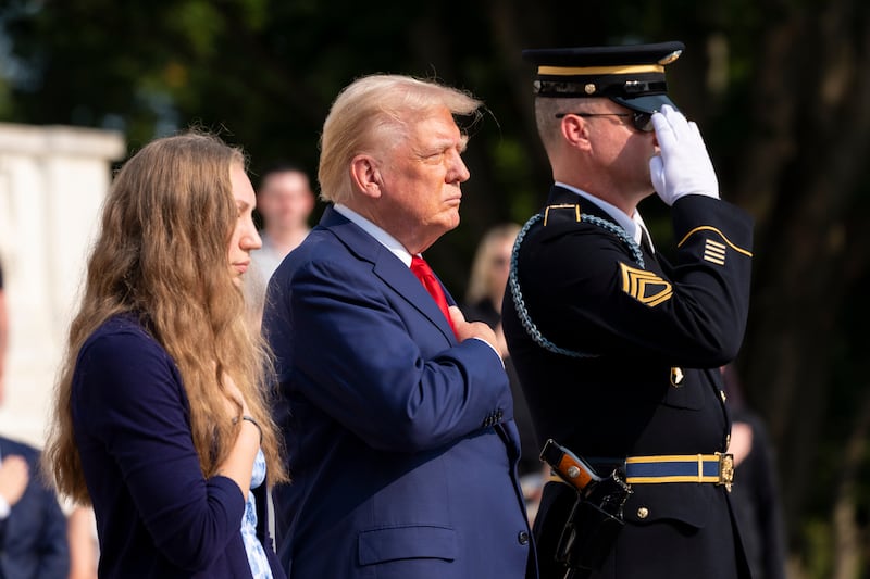 Misty Fuoco, left, sister of Nicole Gee, and Republican presidential nominee Donald Trump place their hands over their heart after placing a wreath in honour of Sgt. Nicole Gee, at the Tomb of the Unknown Solider (Alex Brandon/AP)