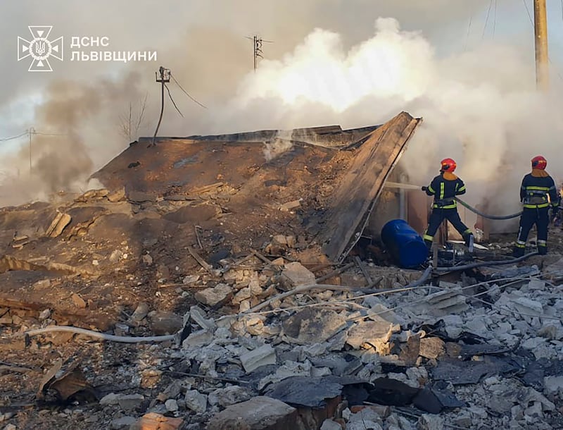 Emergency services personnel work to extinguish a fire following a Russian rocket attack in Lviv, Ukraine (Ukrainian Emergency Service via AP)