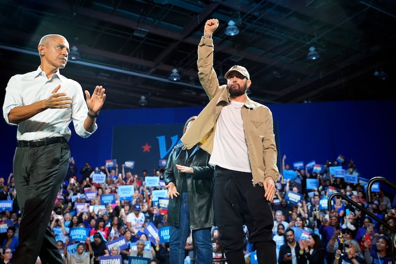 Rapper Eminem, centre, greets the crowd on stage with former President Barack Obama, left, at a campaign rally supporting Democratic presidential nominee Vice President Kamala Harris in Detroit (Paul Sancya/AP)