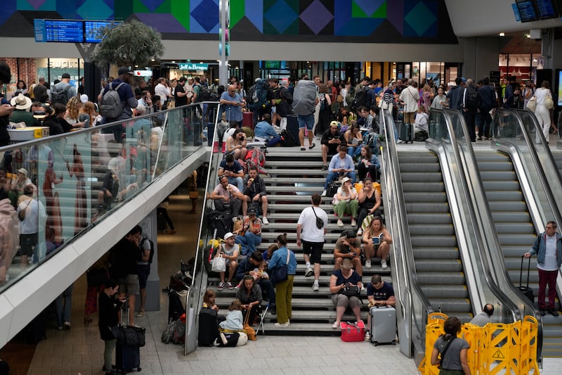 Passengers sit on stairs at the Gare de Montparnasse in Paris (Yasin Dar/AP)