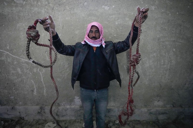 A man holds two ropes tied in the shape of nooses, found in the infamous Saydnaya military prison (Hussein Malla/AP)