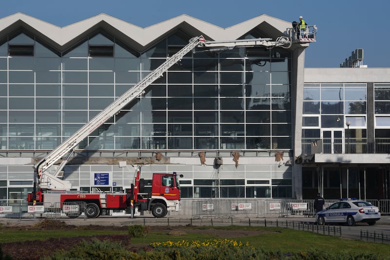 Workers inspect a train station after an outdoor roof collapsed (Darko Vojinovic/AP)