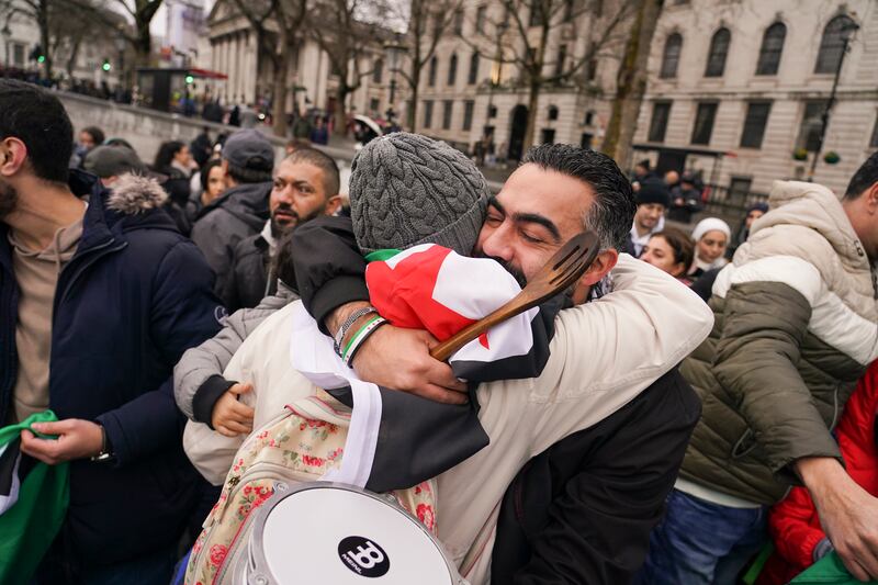 People embrace in London’s Trafalgar Square in celebration at the downfall of Syrian President Bashar Assad (Alberto Pezzali/AP)