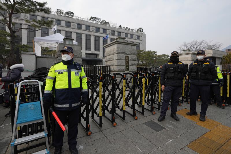 South Korean police officers stand in front of the Constitutional Court in Seoul (Lee Jin-man/AP)