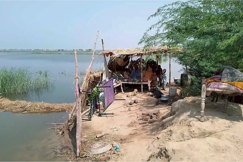 A family take refuge after their house flooded near Sohbat Pur, an area of Pakistan’s southwestern Baluchistan province (AP)