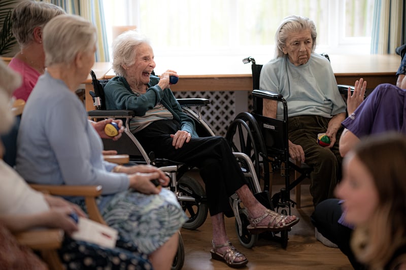 Mary Griffin, 93, centre left, laughs as she plays with a juggling ball