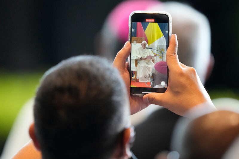 A crowd member takes video of Pope Francis (Mark Baker/AP)