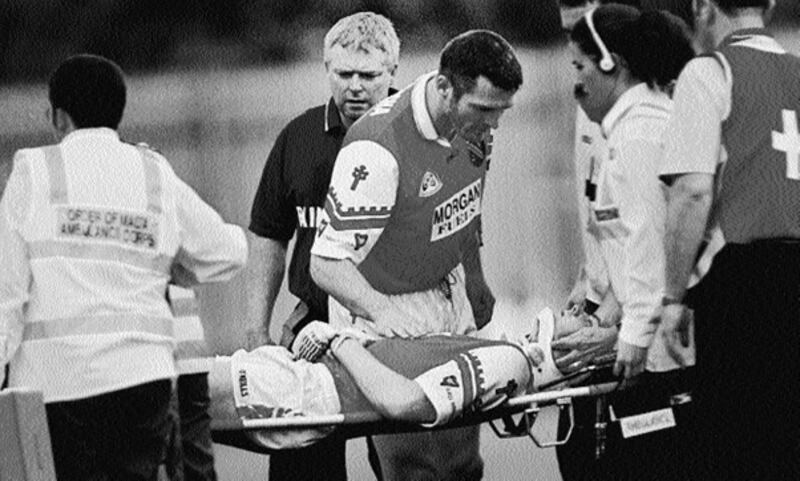 Armagh captain Jarlath Burns checks on Alan O'Neill as he is stretchered off the field at Clones in 1999