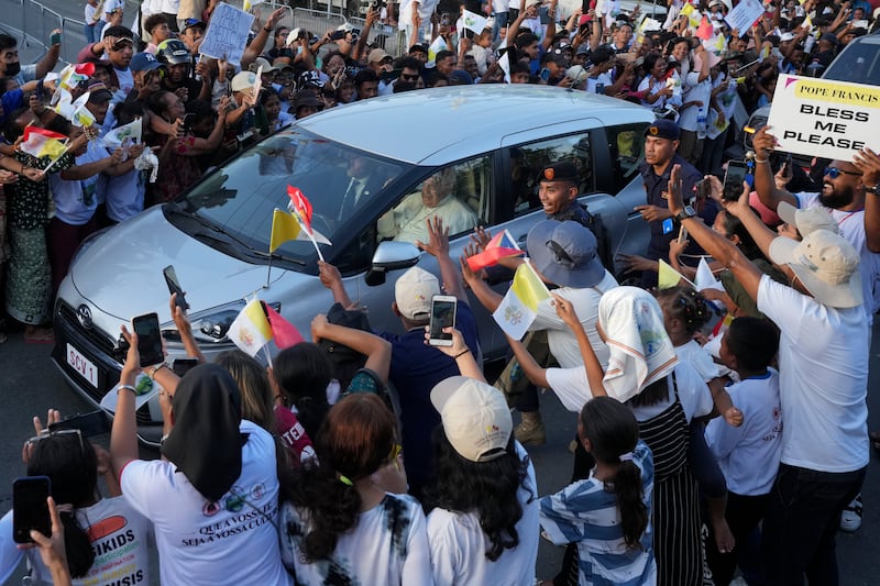 People greet Pope Francis as he travels in a car on the way to the Presidential Palace in Dili, East Timor (Firdia Lisnawati/AP)