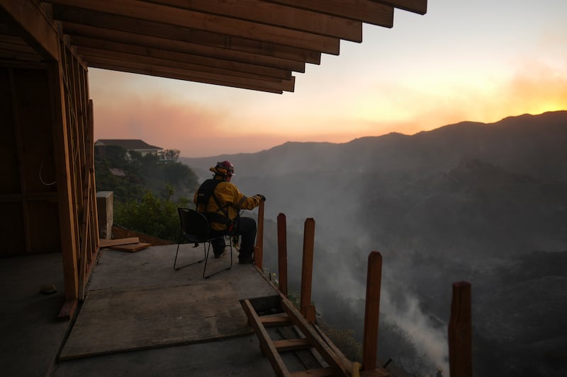 A firefighter rests as crews battle the Palisades Fire in Mandeville Canyon (Eric Thayer/AP)