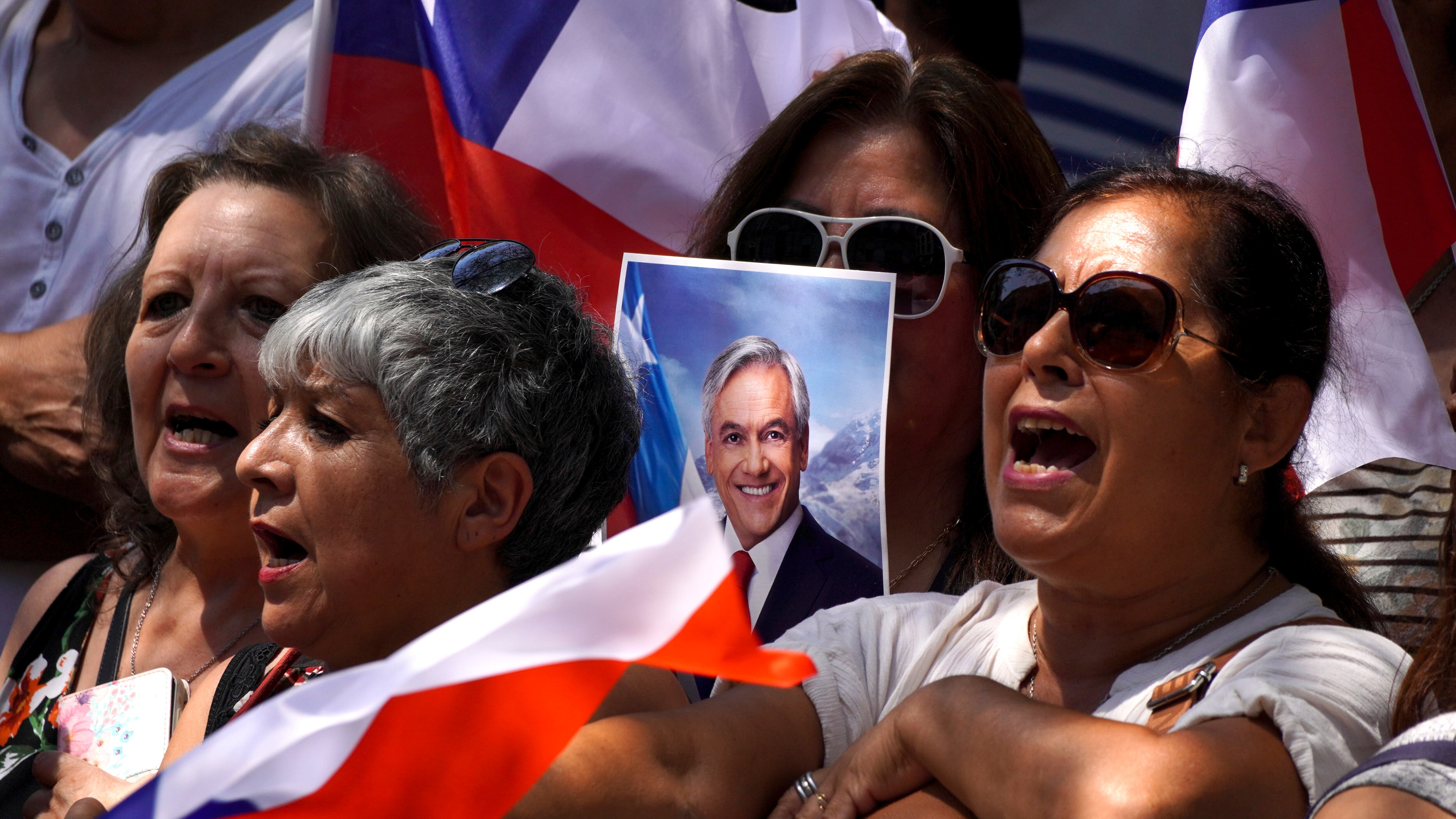 People sing Chile’s national anthem outside Congress as they wait for the arrival of the coffin of Sebastian Pinera (Matias Basualdo/AP)