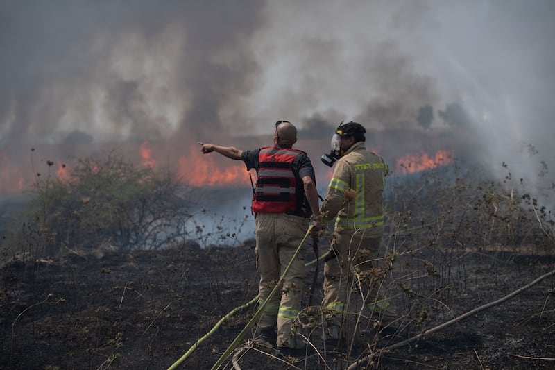 Firefighters work to extinguish a fire following an attack from the Lebanese Hezbollah group in the Israeli-controlled Golan Heights (Gil Eliyahu/AP)