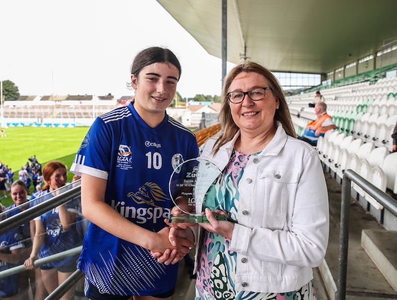 27 July 2024; Ella Sheridan of Cavan receives the Player of the Match award from Trina Murray, LGFA Vice-President, following the ZuCar All-Ireland Ladies Football U-18 Championship A final match between Cavan and Kerry at OConnor Park in Tullamore, Offaly. Photo by Michael P Ryan/Sportsfile *** NO REPRODUCTION FEE ***