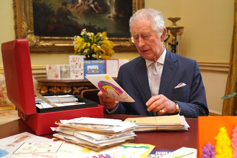 The King reads cards and messages, sent by well-wishers, at Buckingham Palace