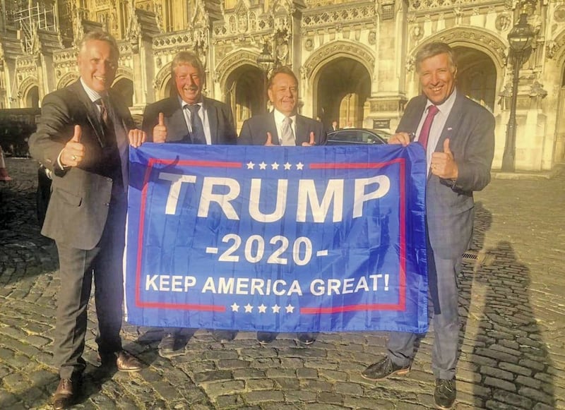 DUP MPs Sammy Wilson, Ian Paisley and Paul Girvan hold a flag supporting Donald Trump in the 2020 US presidential election 