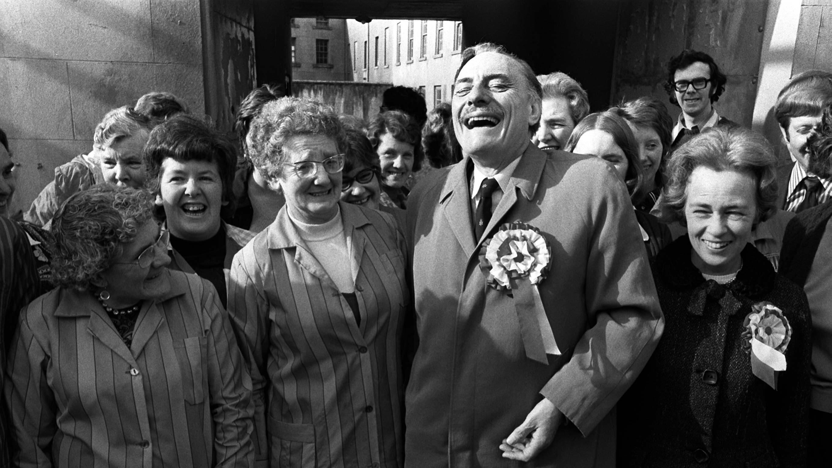 Former Conservative cabinet minister Enoch Powell laughing with his wife Pamela (wearing rosette) and supporters during his election campaign as an United Ulster Unionist candidate for South Down