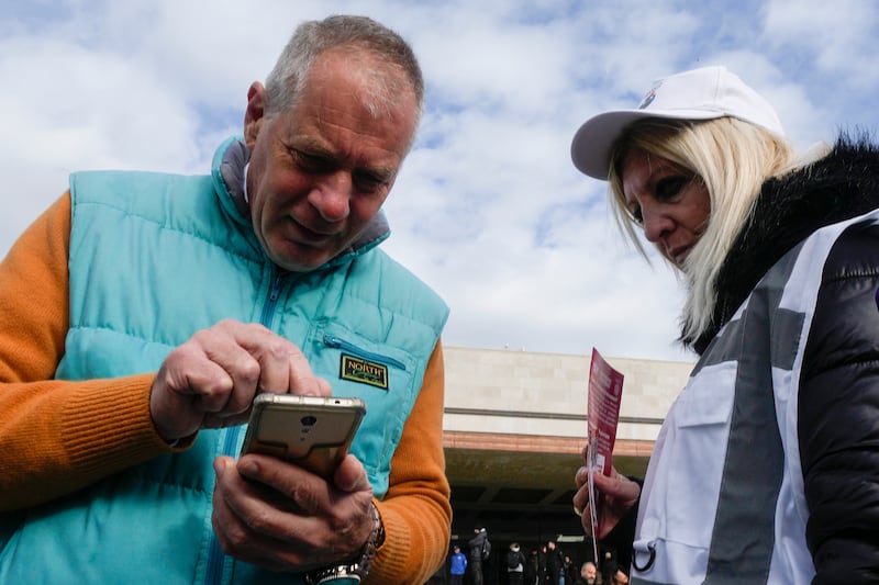 A steward checks a tourist’s access tax QR code outside the railway station in Venice (Luca Bruno/AP)