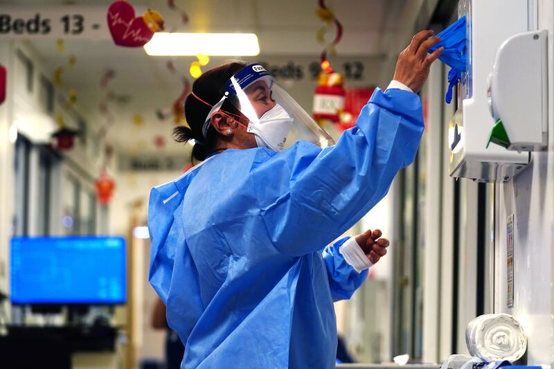 A nurse puts on PPE on a ward for Covid patients at King’s College Hospital, in south east London