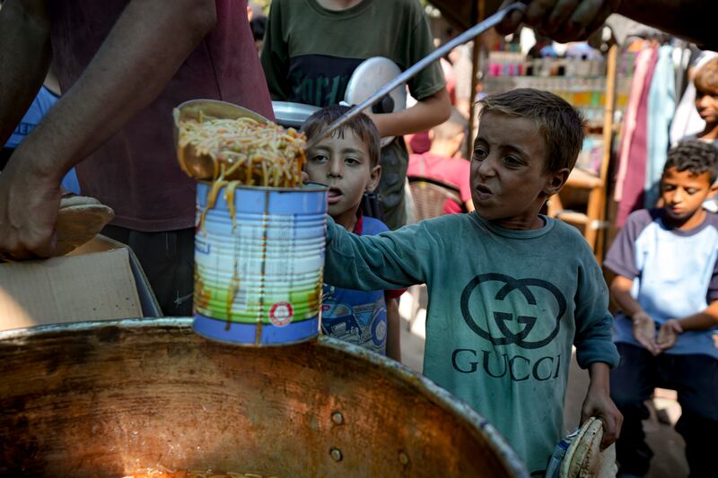 A displaced child lines up for food distribution in Deir al-Balah, Gaza Strip (Abdel Kareem Hana/AP)