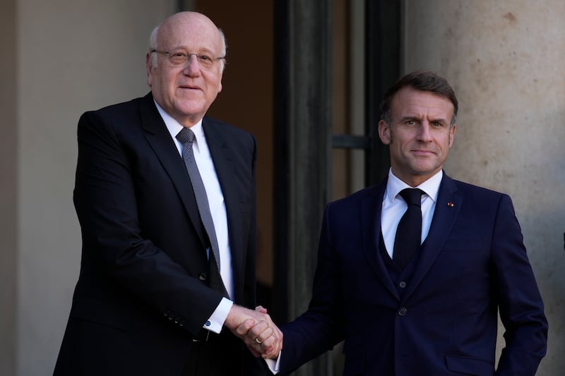 French President Emmanuel Macron welcomes Lebanese caretaker Prime Minister Najib Mikati (Louise Delmotte/AP)