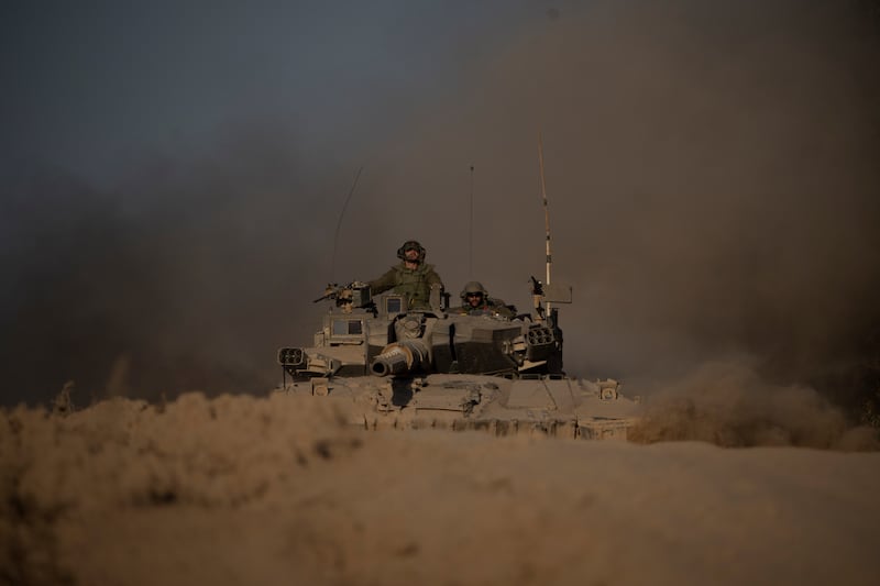 Israeli soldiers move on the top of a tank near the Israeli-Gaza border (Leo Correa/AP)