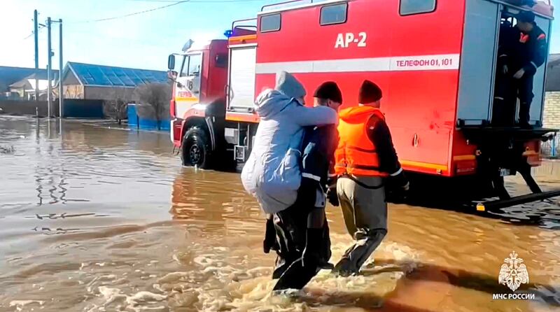 Emergency workers rescue a local resident after part of a dam burst, causing flooding, in Orsk, Russia (Russian Emergency Ministry Press Service/AP)