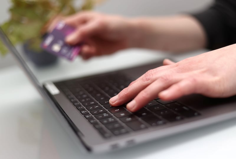 Close up photo of someone typing on a laptop paying a bank transfer