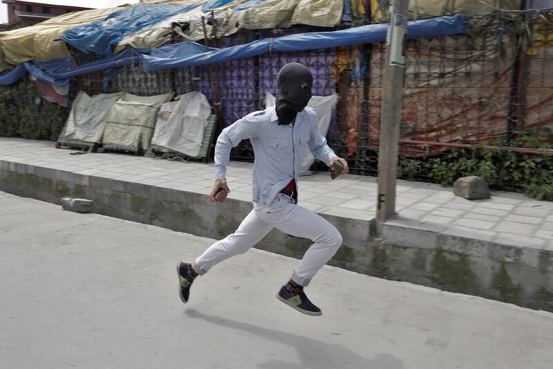 A stone pelter runs towards security forces during disturbances in Srinagar, Kashmir, 2017. Picture by Cathal McNaughton