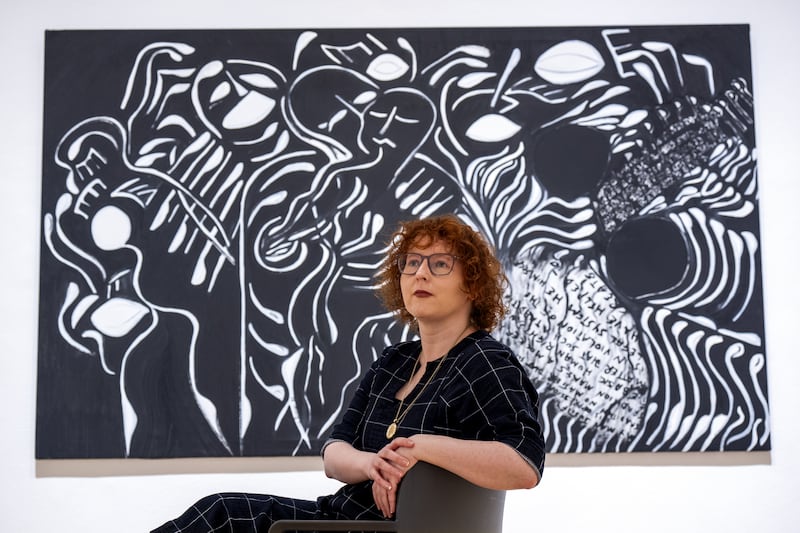 Senior curator Stephanie Straine alongside a 1985 acrylic painting titled Set Free