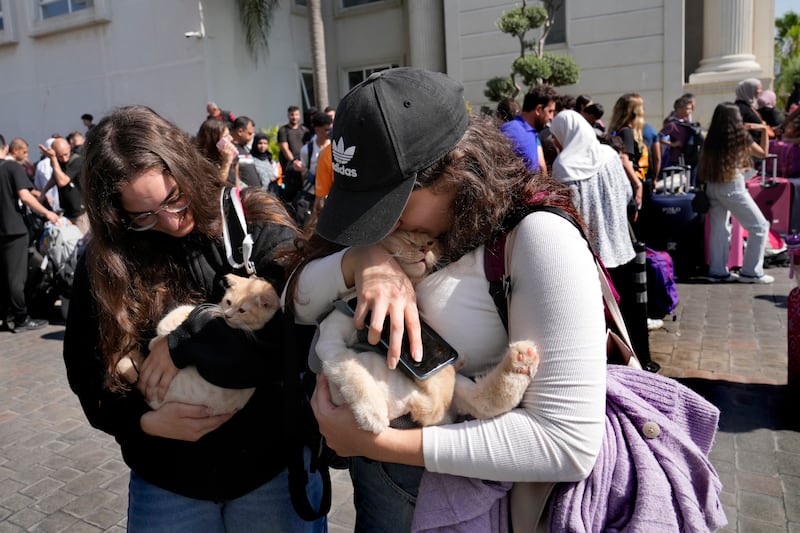 Turkish citizens carry their cats as they wait to board a Turkish navy vessel to be evacuated to Turkey at a gathering point, in Beirut (Hussein Malla/AP)