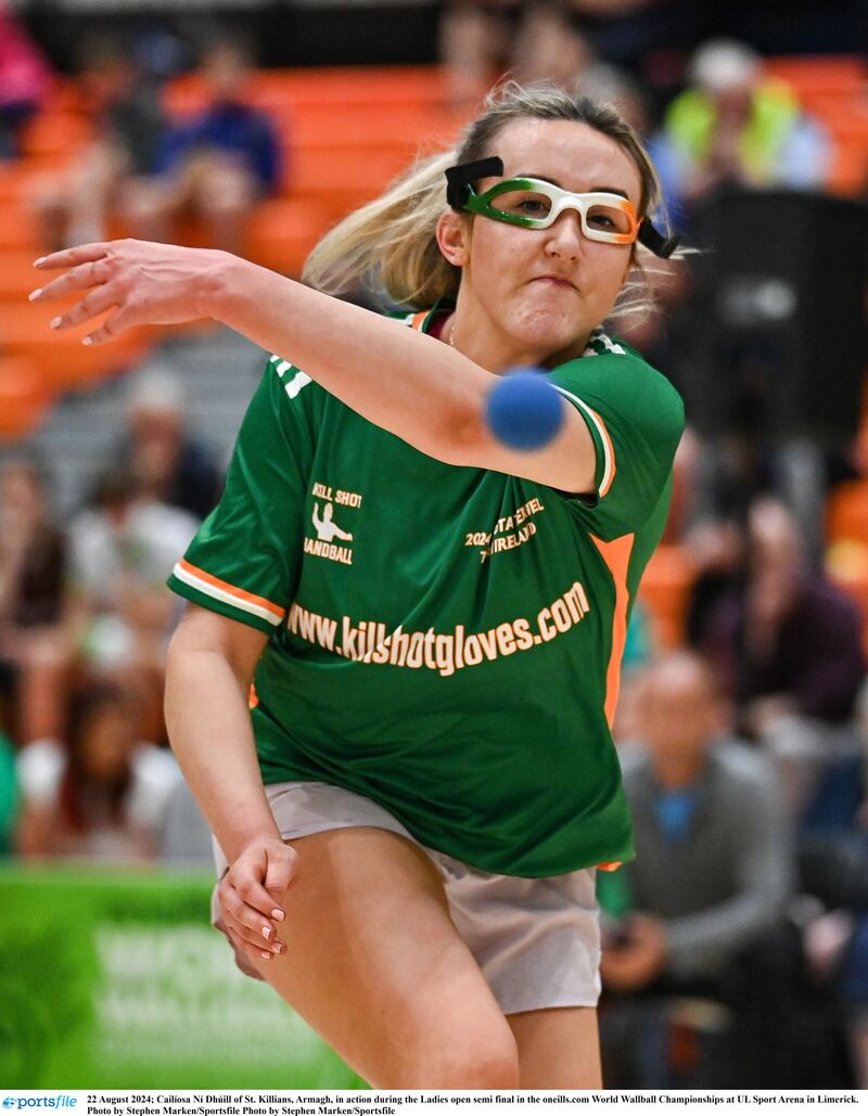 A woman wearing a green jersey and goggles with an Irish tricolour pattern