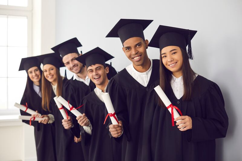 Smiling students take a photo at graduation