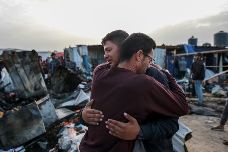 Palestinians react next to the destruction after an Israeli strike in Rafah (AP Photo/Jehad Alshrafi)